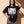 Love Never Ends tee, black, front print, woman, hand in hair thigh up