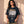 Heart of a Lion faded black tee, front print, woman with long curly hair and hands at her hem, worn with striped track pants
