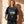 Jesus Is King faded black tee, front print, smiling woman with long wavy hair holding the hem, John 1:1 verse and cross in view