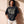 Heart Wide Open faded black tee, front print, woman with curly hair holding the hem, worn with THE WORD sweatpants