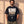 King of Kings faded black tee, front print, bearded man with hands in his pockets and camo cargo pants against a sunlit wall