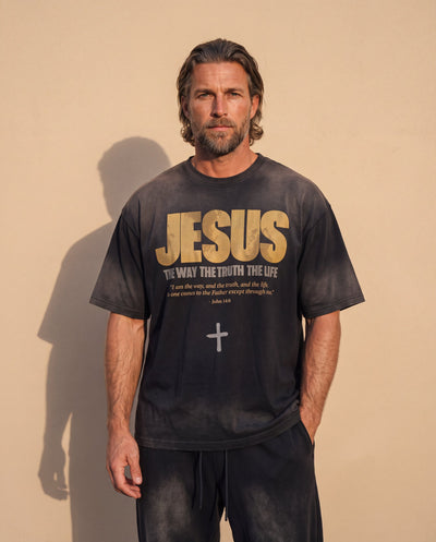 Jesus the Way the Truth the Life faded black tee, front print, man with a beard and hands in his pockets against a sunlit wall