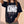 Daughter of the King tee, black, front print, woman, hand in hair waist up