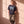 Pray Until Something Happens faded black tee, full body view of a woman leaning on a wall in camo pants and sneakers, Christian streetwear