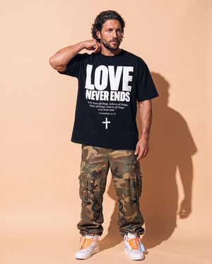 Love Never Ends tee, black, front print, man, hand on neck full body