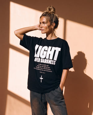 Light Over Darkness tee, black, front print, woman, three quarter thigh up