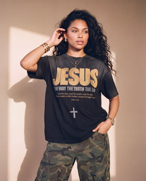 Jesus the Way the Truth the Life faded black tee, woman with one hand by her ear and one in her pocket, Christian streetwear with camo pants