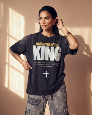 Daughter of the King faded black tee, three quarter angle on a woman with a hand at her ear and one on her hip, showing the boxy fit