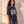 In the Beginning God faded black tee, three quarter angle on a woman with long curly hair, showing the boxy fit and the Genesis verse