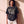 Heart Wide Open faded black tee, front print, woman standing relaxed against a sunlit wall, boxy fit over THE WORD sweatpants