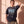 Pray Until Something Happens faded black tee, front print, woman with one hand in her hair, the oversized fit loose over camo pants