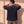 King of Kings faded black tee, back view of a man with both hands behind his head, crown logo centred below the collar