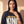 Daughter of the King faded black tee, close up portrait of a woman with a hand at the collar above the DAUGHTER OF THE KING lettering