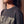 Heart Wide Open faded black tee, close up of a woman's neckline and dropped shoulder, the distressed HEART lettering below