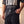 Heart of a Lion faded black tee, close crop on a man holding the hem, the Daniel 6:23 verse and cross above his cargo pants