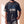 Jesus Is King faded black tee, front print close crop on a man holding the hem, John 1:1 verse and cross, Christian streetwear