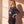 Jesus Is King faded black tee, side profile of a woman with a hand on her hip, showing the relaxed length and boxy oversized cut