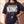 Daughter of the King faded black tee, front print close crop on a woman holding the hem, the verse and cross, Christian streetwear