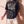 Heart Wide Open faded black tee, front print, woman with open palms at her sides, boxy fit with the full verse and cross
