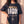 Heart of a Lion faded black tee, front print close crop on a woman with a hand on her hip, the Daniel 6:23 verse and cross in full