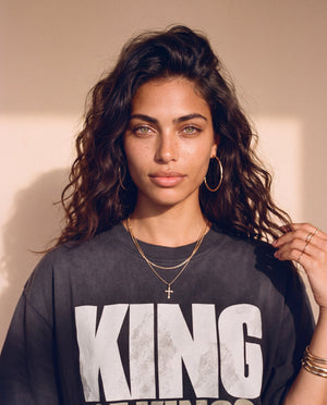 King of Kings faded black tee, close up portrait of a woman with curly hair and a cross necklace above the large KING lettering
