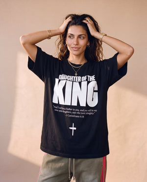 Daughter of the King tee, black, front print, woman, hands in hair thigh up
