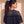 King of Kings faded black tee, back view of a woman with a curly ponytail and hoop earrings, small crown logo under the neckline
