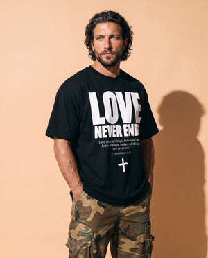 Love Never Ends tee, black, front print, man, hands in pockets thigh up