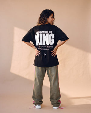 Daughter of the King tee, black, back print edition, woman, back print hands on hips full body