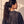 In the Beginning God faded black tee, back view of a woman with a curly ponytail, crown logo and THE WORD under the neckline