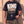 King of Kings faded black tee, close crop on a man's torso, the Revelation 17:14 verse and cross with one hand at the hem