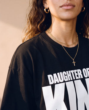 Daughter of the King tee, black, front print, woman, collar close up with gold cross necklace