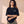 Daughter of the King tee, black, back print edition, woman, front crown arms crossed thigh up
