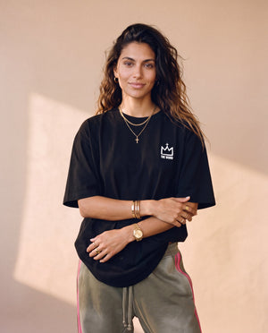 Daughter of the King tee, black, back print edition, woman, front crown arms crossed thigh up
