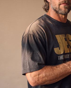 Jesus the Way the Truth the Life faded black tee, close up on a man's shoulder and chest, the sunfaded sleeve and the JESUS lettering