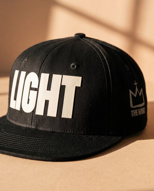 LIGHT snapback cap, close-up of the raised front print