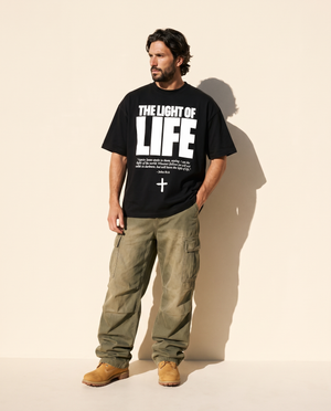 The Light of Life tee, black, front print, man, hand in pocket full body
