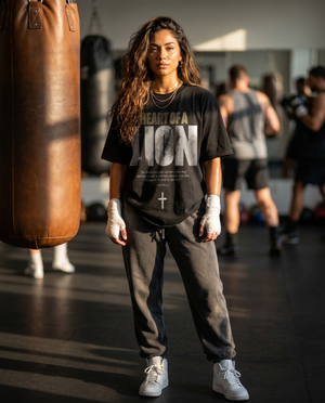 Heart of a Lion – Woman in boxing gym wearing The Word black t-shirt and sweatpants