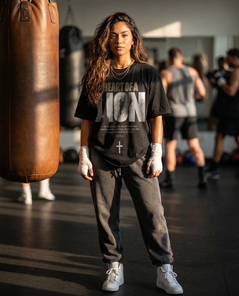 Heart of a Lion – Woman in boxing gym wearing The Word black t-shirt and sweatpants