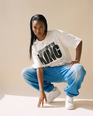 Daughter of the King MONOCHROME tee, white, woman, front print full body crouching in blue joggers