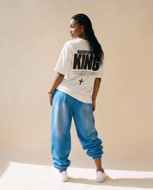 Daughter of the King MONOCHROME tee, white, back print edition, woman, back print full body standing in blue joggers