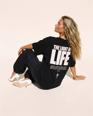 The Light of Life MONOCHROME tee, black, back print edition, woman, back print seated