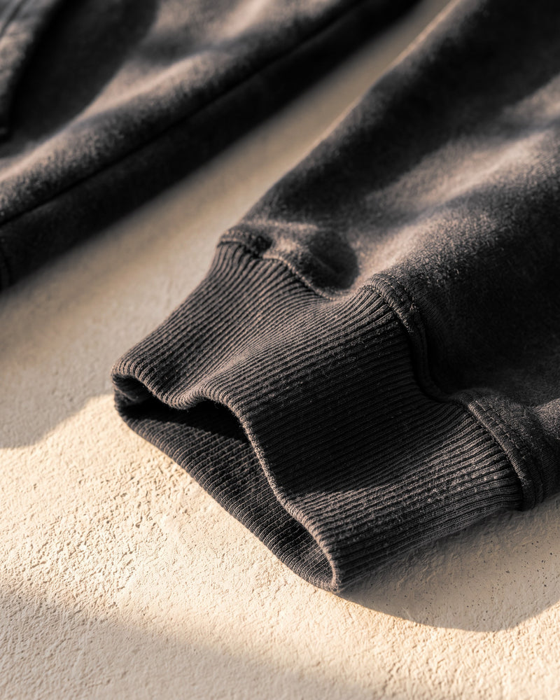 Black faded hoodie, ribbed cuff, close-up