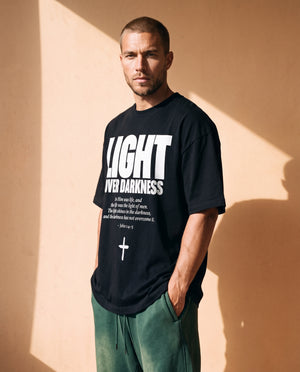 Light Over Darkness tee, black, front print, man, three quarter thigh up