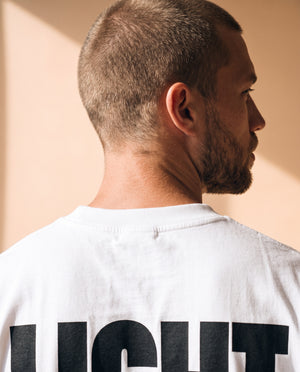 Light Over Darkness tee, white, back print edition, man, back print over shoulder close up