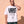 Light Over Darkness tee, white, front print, man, hand on neck thigh up