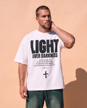 Light Over Darkness tee, white, front print, man, hand on neck thigh up