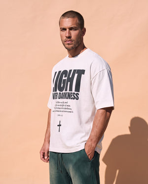 Light Over Darkness tee, white, front print, man, three quarter thigh up