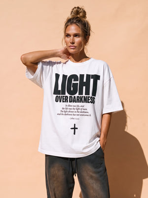 Light Over Darkness tee, white, front print, woman, hand on neck thigh up