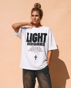 Light Over Darkness tee, white, front print, woman, hand on neck thigh up